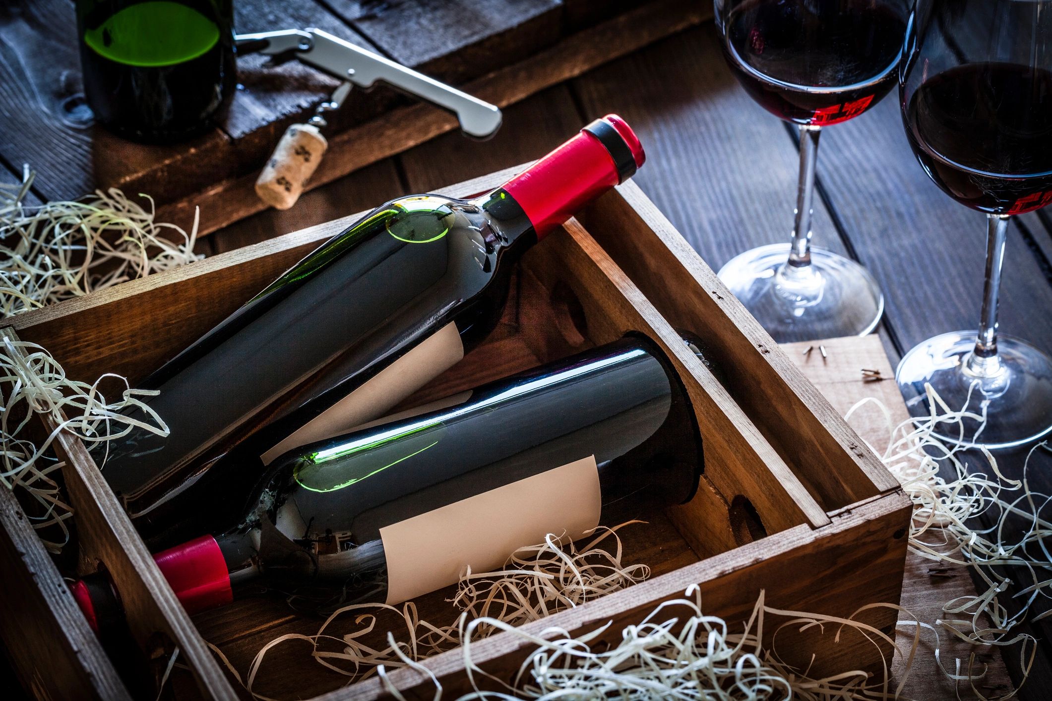 Wine bottles packed in a wooden box on a rustic table